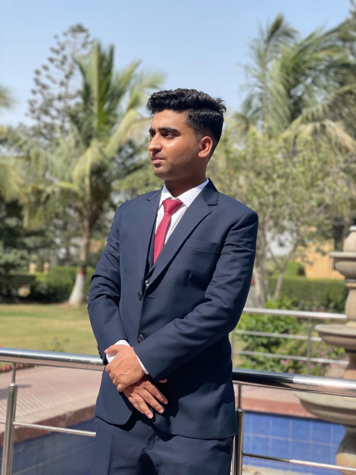 Muneeb Ur Rehman in a navy suit, side profile